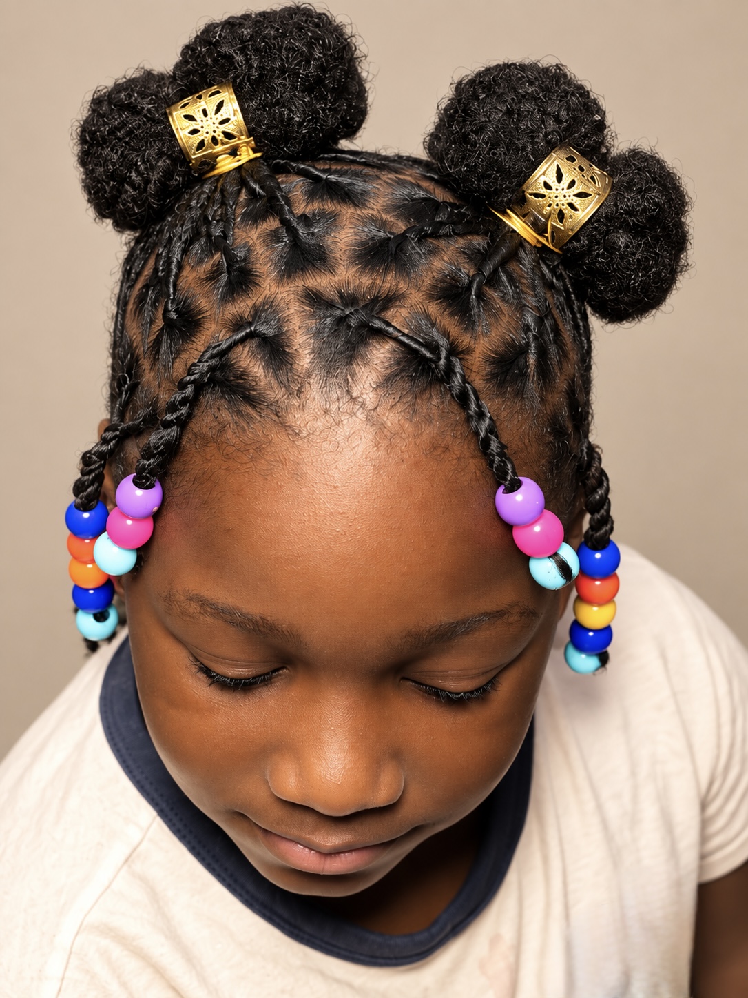 Children’s braided buns with colorful beads and gold cuffs